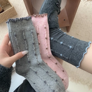 Detail of wool blend socks featuring cute colorful dots and elegant frill cuffs