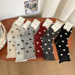 Flat lay of six pairs of wool-blend knit socks with polka dots and rolled edges