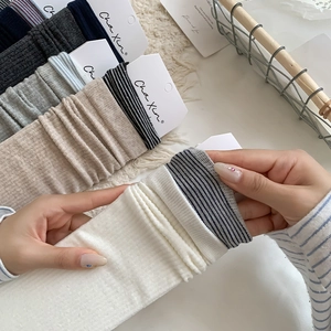 Detailed texture of cotton ribbed crew socks in beige, grey, and striped patterns