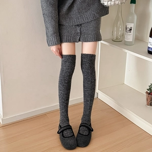 Detailed texture of charcoal grey knitted over-the-knee socks with wool-like fabric