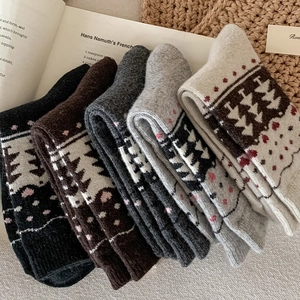 Close-up of five pairs of thick knit wool socks with Nordic Christmas tree patterns
