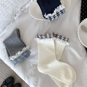 Détail de bordure en dentelle et revers à carreaux gris sur chaussettes en coton