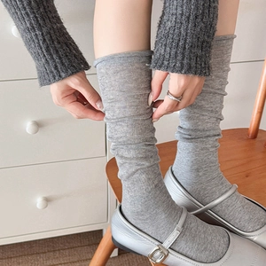 Close-up of gray ribbed slouch socks paired with silver Mary Jane shoes in soft lighting