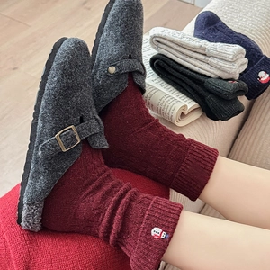 Detail of red wool socks with snowman embroidery and chunky knit texture for winter