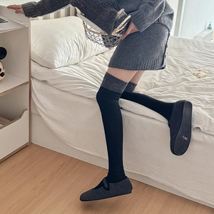 Detail der warmen Overknee-Strümpfe in Schwarz und Grau aus Strick für Herbst und Winter