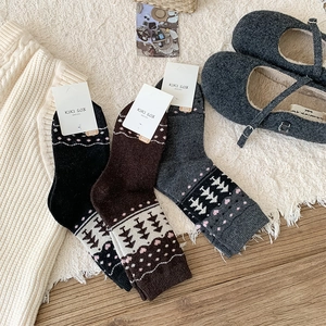 Detailed view of thick wool Christmas tree socks in grey and coffee with retro patterns