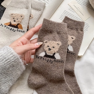 Close-up of thick knitted teddy bear socks in beige and brown for winter warmth
