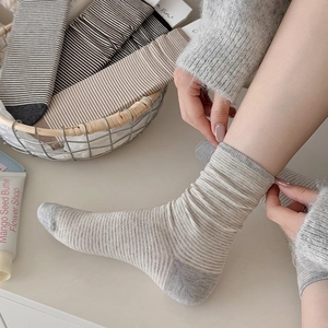 Close-up of assorted striped crew socks in a basket with high-quality knit texture