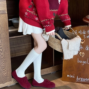 Vintage white cable knit knee-high socks paired with dark red lace-up flat shoes