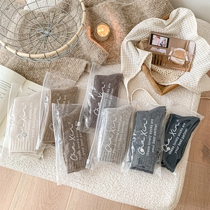 Close-up of assorted wool socks in earth tones packaged in premium PVC zipper bags