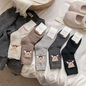 Detail of five pairs of warm wool socks with teddy bear embroidery and KIKI tags