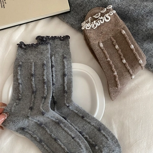 Detail of wool crew socks with vertical stripes, polka dots and lettuce edge trim