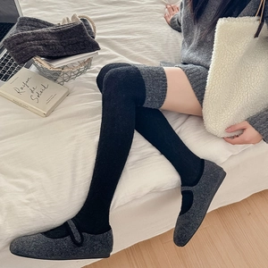 Schwarze Vintage-Overknees aus Strick kombiniert mit grauen Mary-Jane-Flachschuhen