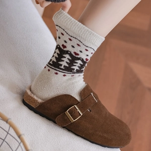 Detail of warm brown suede mules with soft sherpa lining and vintage buckle accents