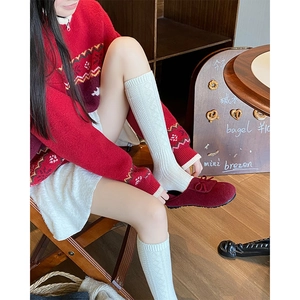 Close-up of white knit knee-high socks with diamond cable pattern and vintage aesthetic