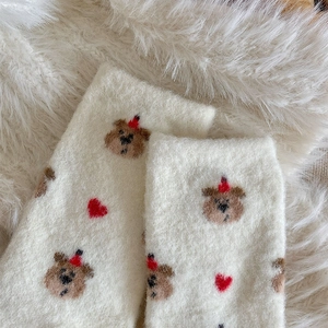 Detailaufnahme weicher beiger Kuschelsocken mit Bärenmotiv und roten Herzen