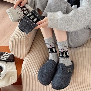 Winter thermal knit mid-calf socks featuring Nordic Christmas tree patterns in cozy home setting