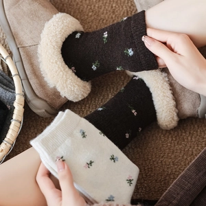 Detailed embroidery of small floral patterns on thick wool socks for winter warmth