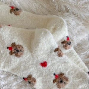 Makro-Detail von flauschigen Socken mit Bärenmuster und dicker, warmer Plüsch-Textur
