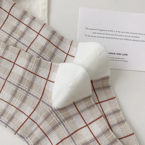 Gros plan de chaussettes à carreaux vintage avec talon blanc et texture en coton tricoté
