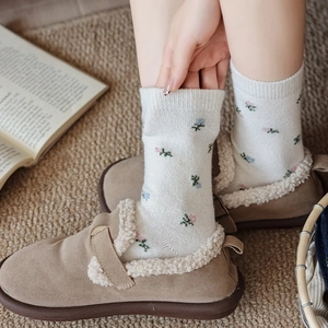 Detailed knit texture of vintage floral wool socks paired with warm sheepskin shoes