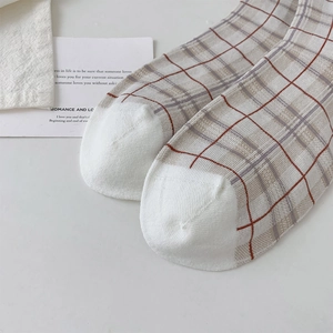 Vue détaillée des chaussettes à carreaux vintage en beige et marron avec pointe blanche
