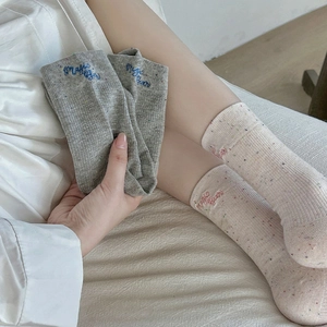 Détails des chaussettes mouchetées avec broderie Magic Bear et texture côtelée
