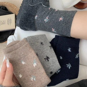 Detail of thick wool socks with cute floral embroidery and warm knitted texture