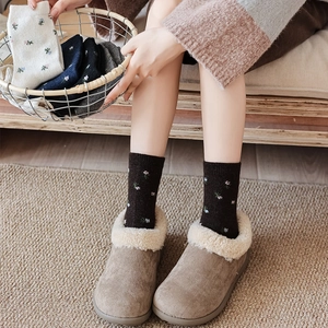 Detail of floral embroidered wool socks for women with warm lining shoes in cozy setting