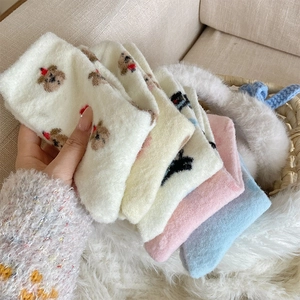 Nahaufnahme dicker Plüsch-Korallenfleece-Socken mit süßer Cartoon-Bärenstickerei