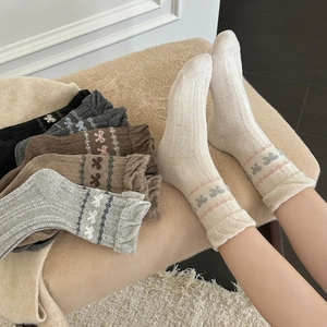 Detail von Wollmisch-Stricksocken mit feinem Schleifen-Jacquard und gewelltem Rüschenrand