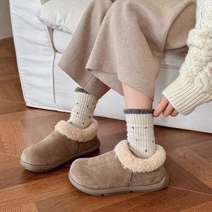 Close-up of camel suede mule slippers with plush faux shearling lining and thick rubber soles