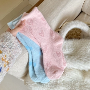 Nahaufnahme dicker Korallenvlies-Wintersocken mit Herzmuster in Rosa und Blau