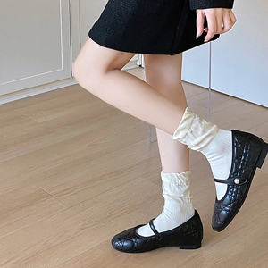 Schwarze gesteppte Mary Jane Schuhe mit Perlenverzierung und weißen Spitzensocken