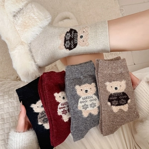 Detailed knit texture of wool socks featuring cute cartoon teddy bear jacquard patterns