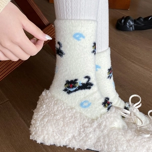 Detailansicht von Strick-Socken mit süßem Katzenmuster und blauen Buchstaben-Details