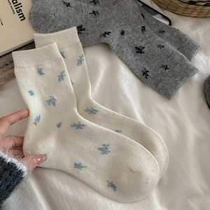Detailed knit texture of floral wool socks in beige and grey for winter warmth