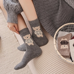 Close-up of thick winter wool socks with cute cartoon bear jacquard pattern details