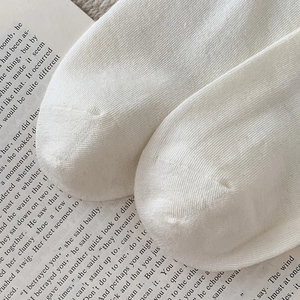 Close-up of white rib-knit socks texture on vintage book background
