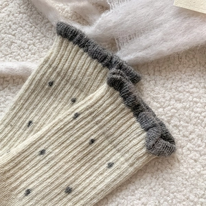Close-up of retro wool socks with polka dots and ribbed cuffs for cozy winter wear