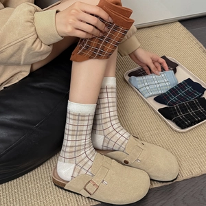 Détail de chaussettes mi-hautes en tricot à carreaux vintage aux couleurs d'automne
