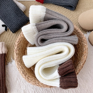 Gros plan de jambières en tricot côtelé épais aux couleurs contrastées dans un panier