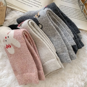 Detail of knitted winter wool socks with cute animal jacquard patterns in various colors