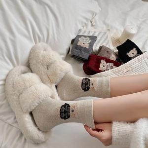 Cozy winter wool socks set with cute bear patterns and plush slippers in home setting