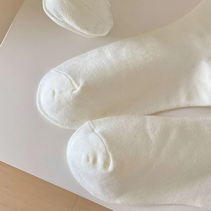 Nahaufnahme der nahtlosen Zehenpartie und der weichen Strickstruktur weißer Socken
