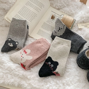 Detailed knit of thick wool socks featuring cute cartoon bear and bunny patterns