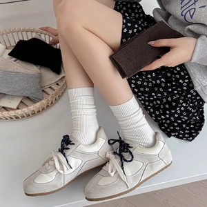 Close-up of grey ribbed slouch socks paired with retro sneakers for a casual autumn style