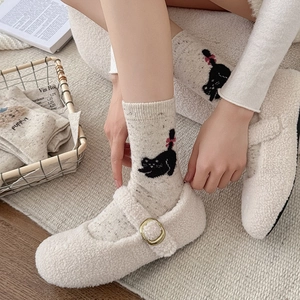 Détails de la maille de chaussettes en laine crème avec motifs chat et nœud rose