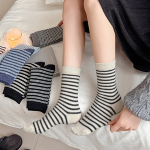 Detailed view of striped wool-blend socks in various colors on a soft minimalist background