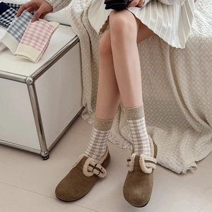 Detailed close-up of plaid cotton crew socks paired with fleece-lined brown suede shoes